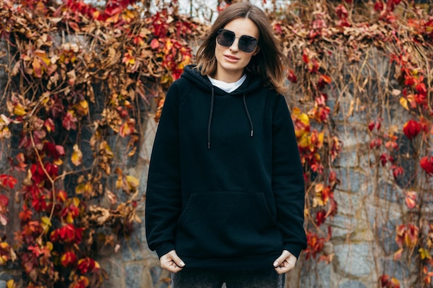 Young woman in glasses and black hoodie