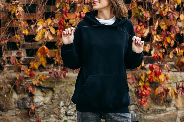 Young woman in glasses and black hoodie