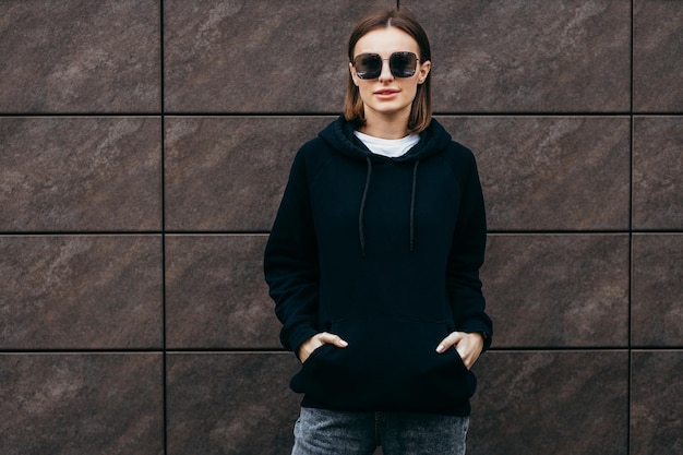 Young woman in glasses and black hoodie