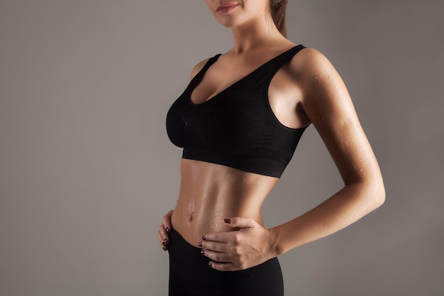 Young woman in good sports shape showing her ideal press