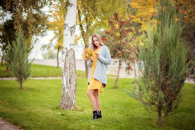 Young woman in a gray cardigan in the autumn park