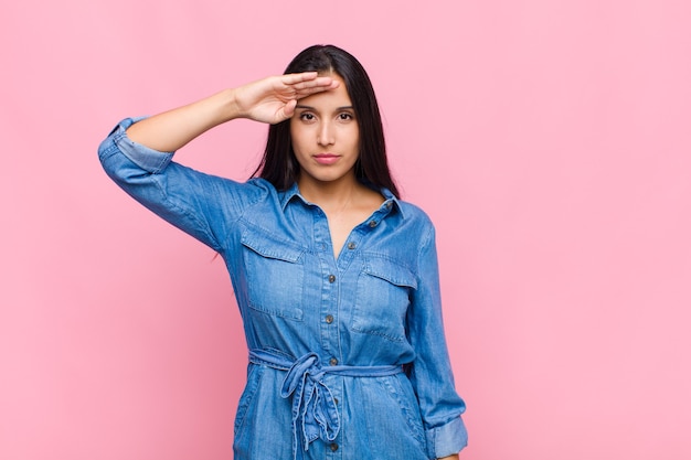 Young woman greeting with a military salute in an act of honor and patriotism, showing respect