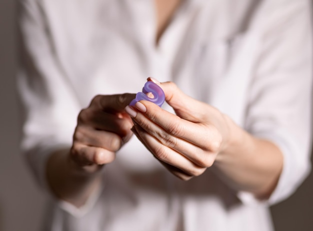 Young woman hand holding menstrual cup Selective focus and shallow DOF