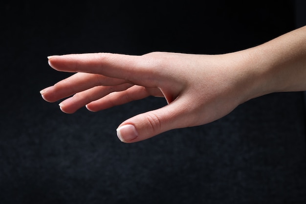 Young woman hand isolated on black background