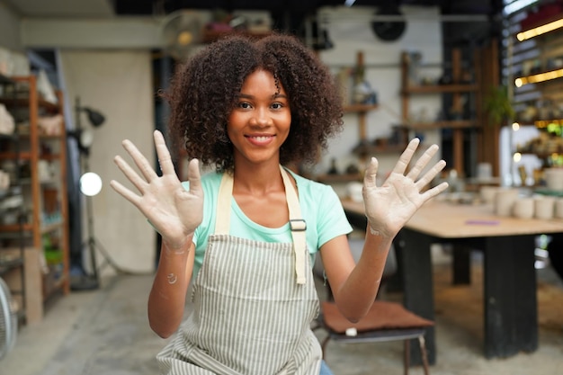 Young Woman hand potter making clay vase in pottery workshop Business owner