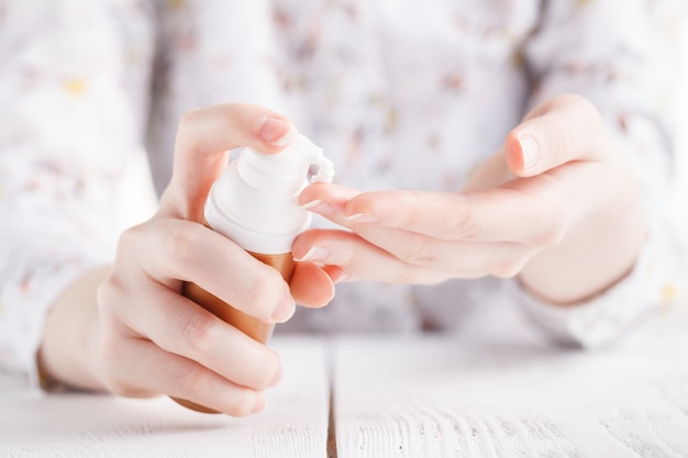 Young woman hands applying moisturizing cream to her skin