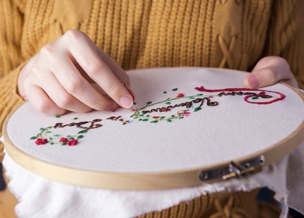 Young woman hands are embroidered happy valentines day