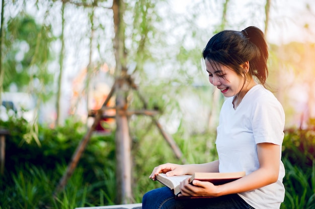 Young woman happily reading the book in nature