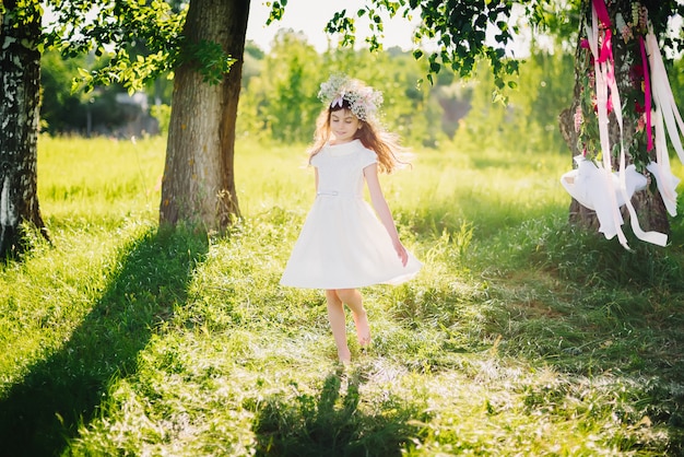 Young woman happily spinning in the meadow in nature on a summer day