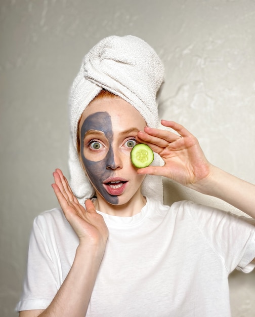 Young woman has applied a gray clay mask