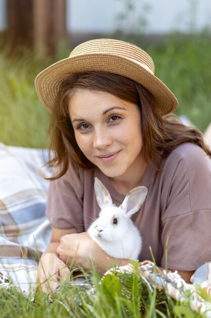 Young woman in a hat with a white rabbit