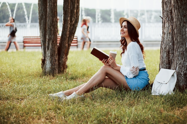 Young woman have weekend and sits in the park at daytime