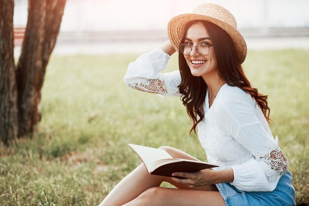 Young woman have weekend and sits in the park at daytime