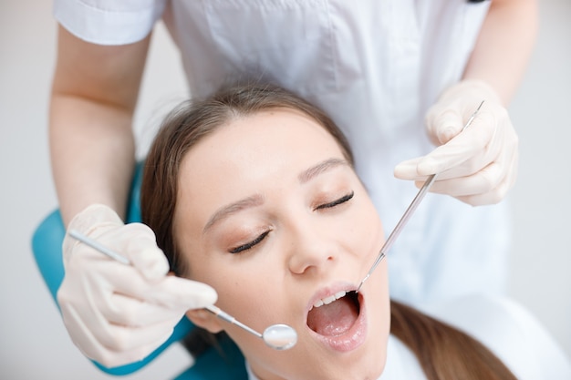 young woman having dental treatment at dentists office