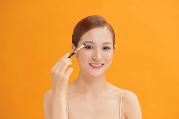 A young woman having eyeshadow added to her eyelids