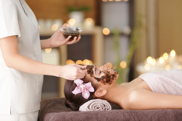 Young woman having face treatment in spa salon