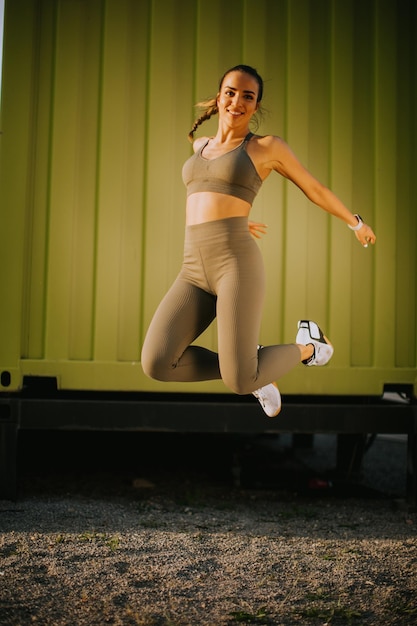 Young woman having outdoor jumping exercise