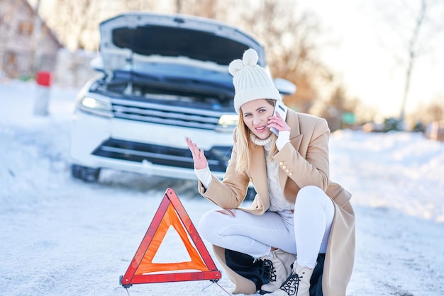 Young woman having problem with car in winter. High quality photo