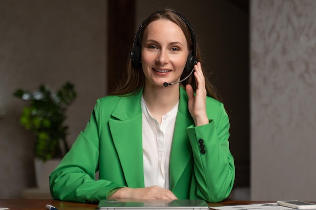 Young woman in headset speaks to camera sitting at table