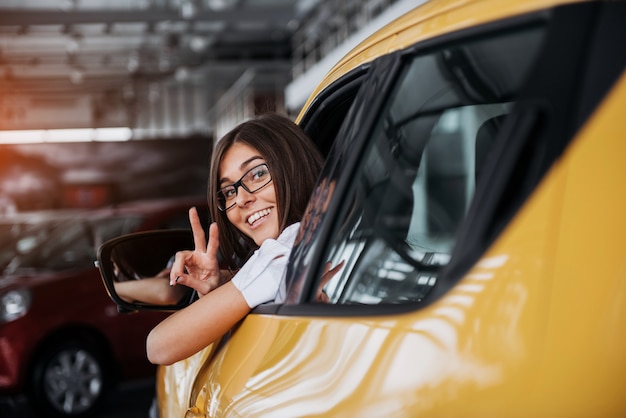 Young woman in her new car smiling