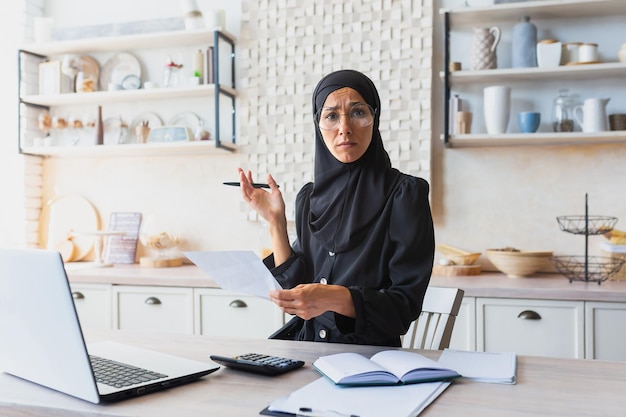 Young woman in hijab muslim freelancer businesswoman working online at home with laptop and