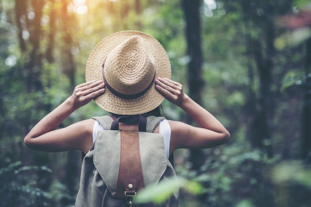 Young woman hiker with backpack watching trekking map, Hiking concept.