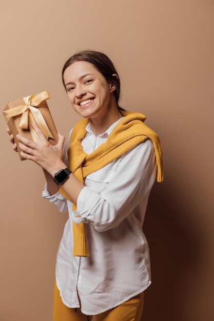 Young woman hold new year handmade present packed in kraft paper close up portrait