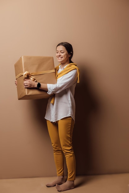 Young woman hold new year handmade present packed in kraft paper