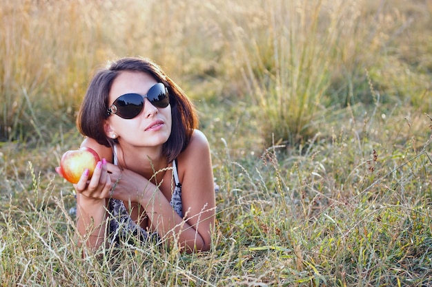 Young woman holding apple in her hand