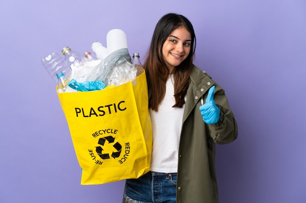 Young woman holding a bag full of plastic bottles to recycle