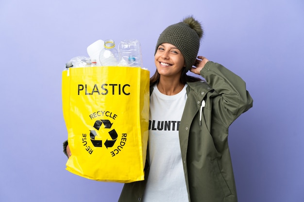 Young woman holding a bag full of plastic having doubts