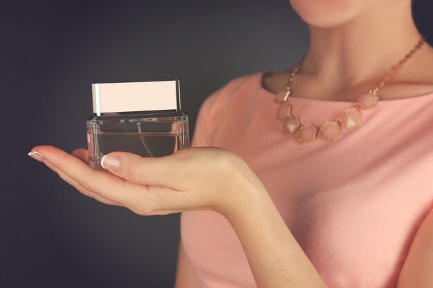 Young woman holding bottle perfume