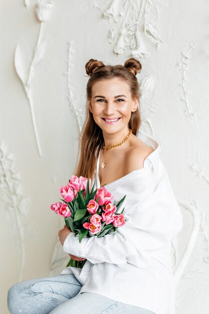 Young woman holding bunch of flowers