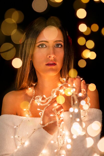 Photo young woman holding christmass string lights