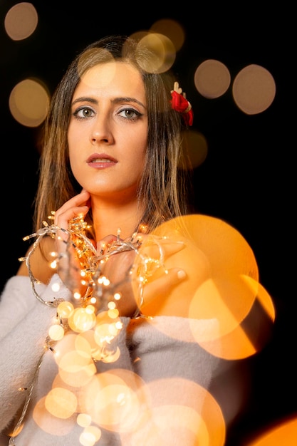 Photo young woman holding christmass string lights