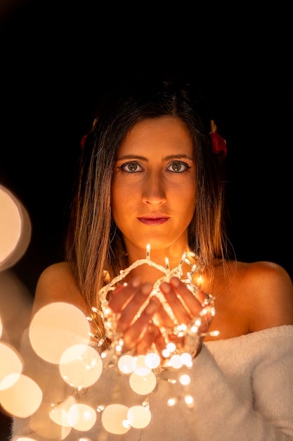 Photo young woman holding christmass string lights