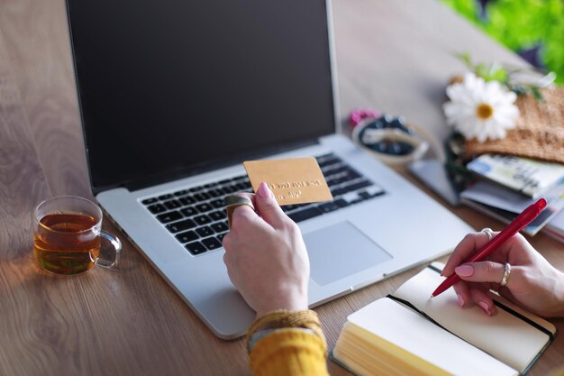 Young woman holding credit card and using laptop computer Online shopping concept