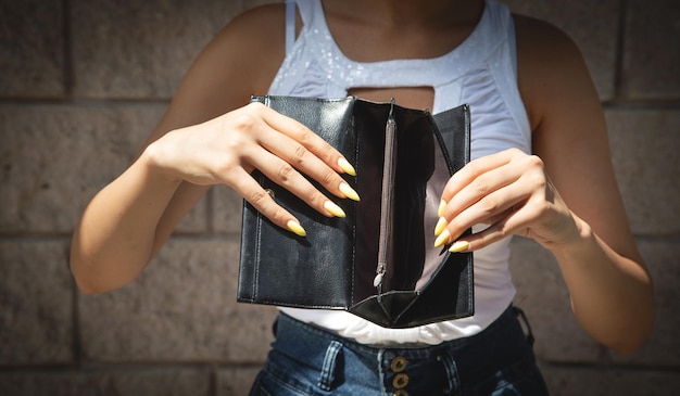 Young woman holding empty wallet No Money