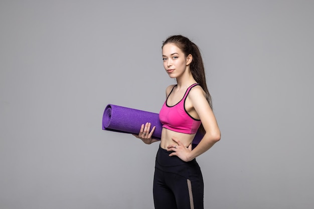 Young Woman Holding Exercise Mat Isolated On White