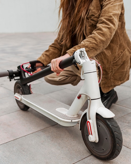 Photo young woman holding her electric scooter