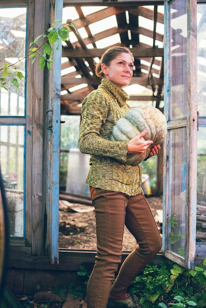 A young woman holding in her hands a pumpkin