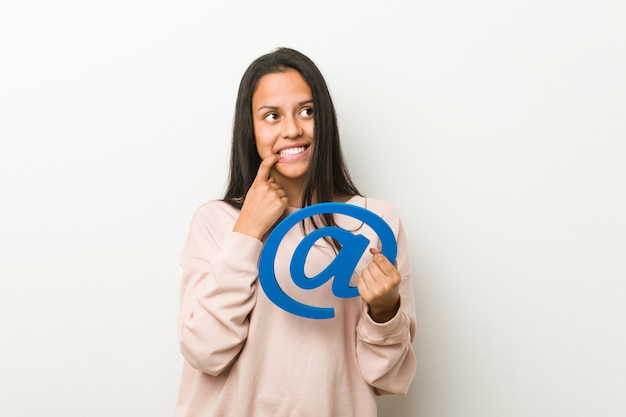 Young woman holding an at icon relaxed thinking about something