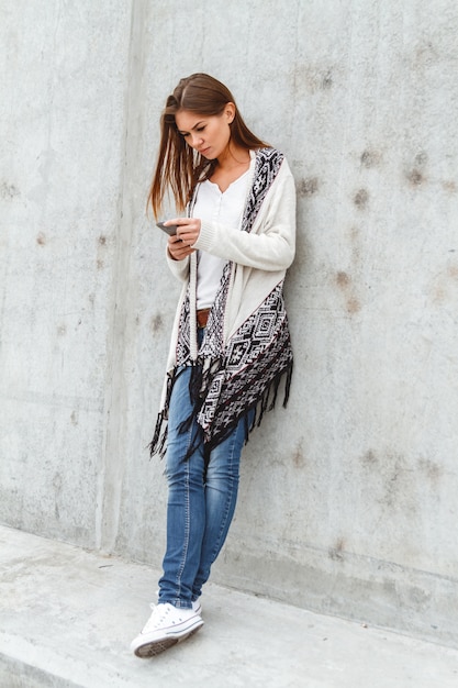 Young woman holding a mobile phone in hands