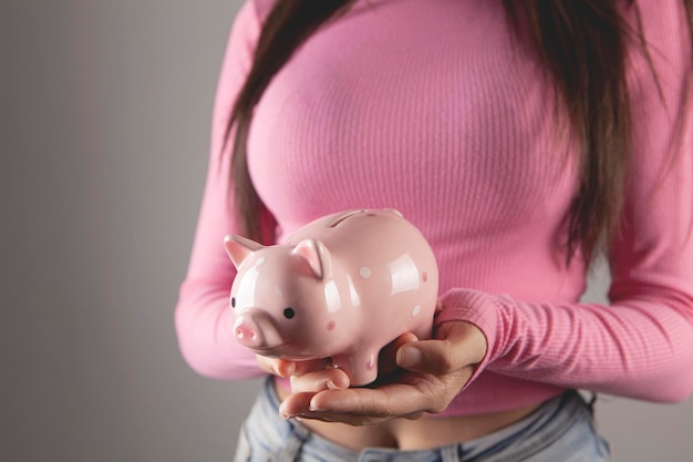 Young woman holding a piggy bank in her hands