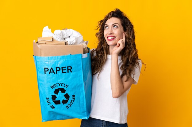 Young woman holding a recycling bag full of paper to recycle