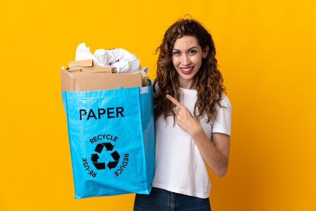 Young woman holding a recycling bag full of paper to recycle