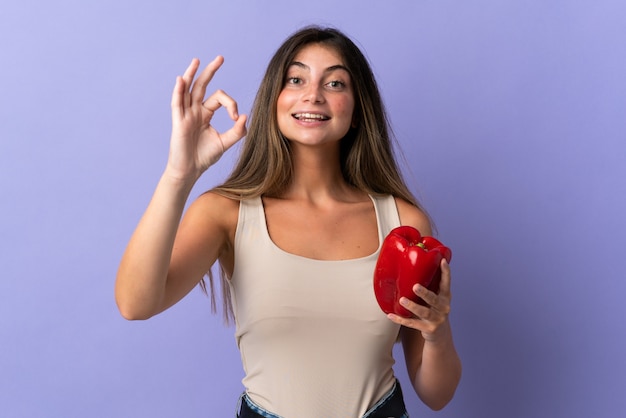 Young woman holding a red pepper