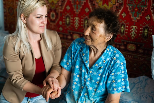 Young woman holding senior woman's hand