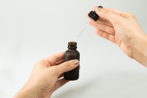 Young woman holding a serum pipette isolated.