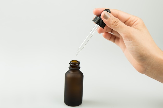 Young woman holding a serum pipette